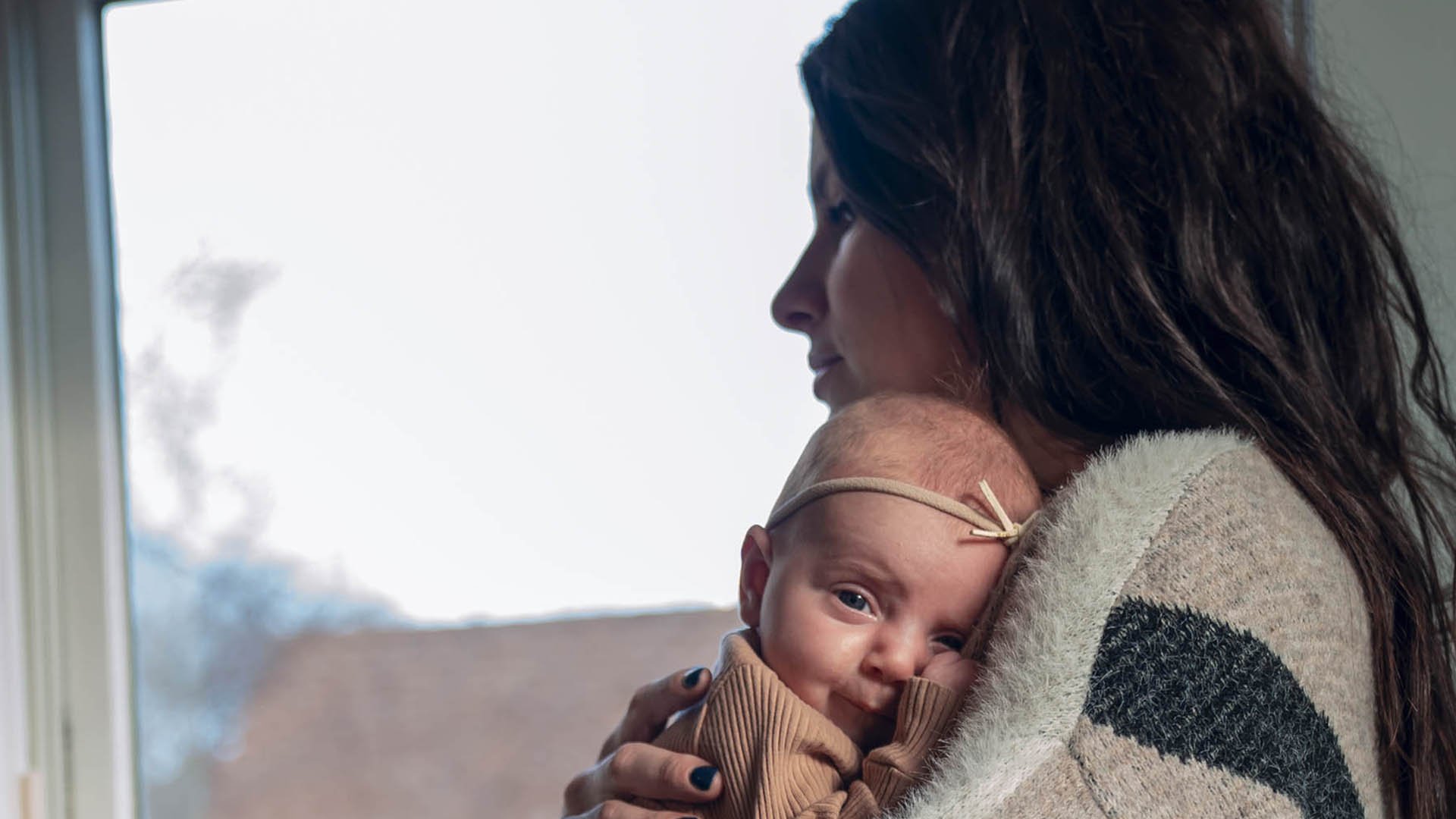 A mother holds a newborn in her arms.