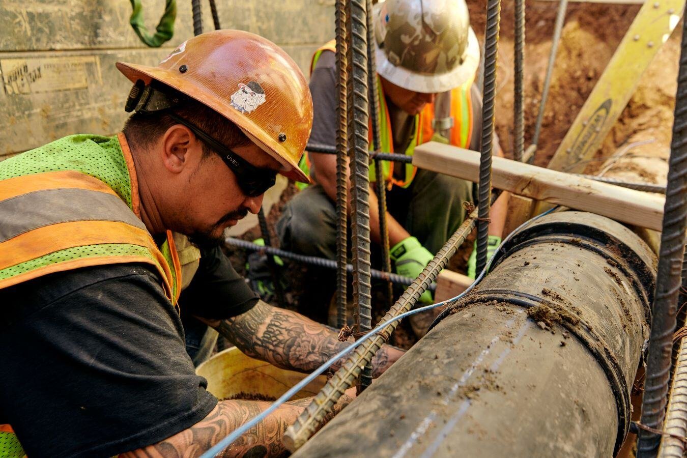 Two employees working on a water main. 