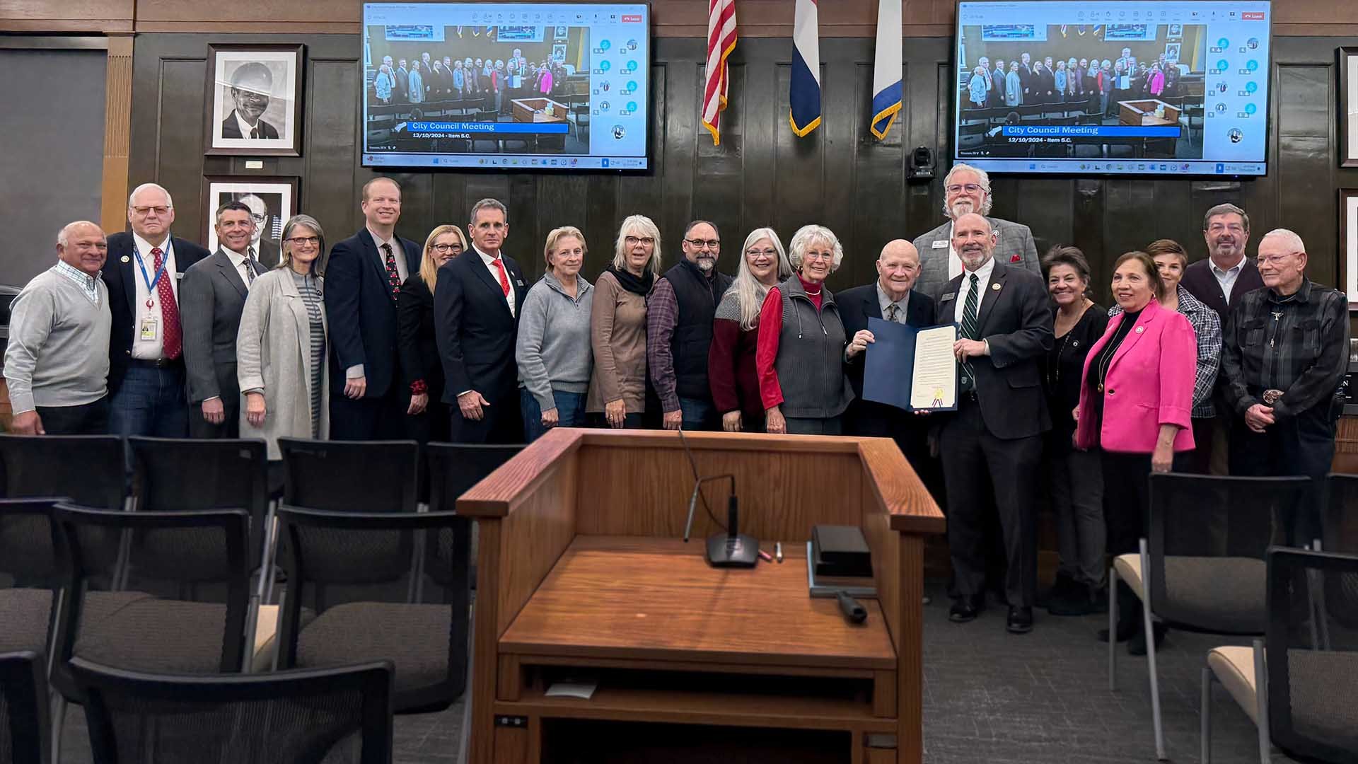 Colorado Springs City Council member and Colorado Springs Utilities workers pose with Harold Miskel in council chambers.