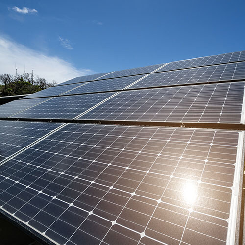 A close-up photo of solar panels with a clear blue sky in the background.