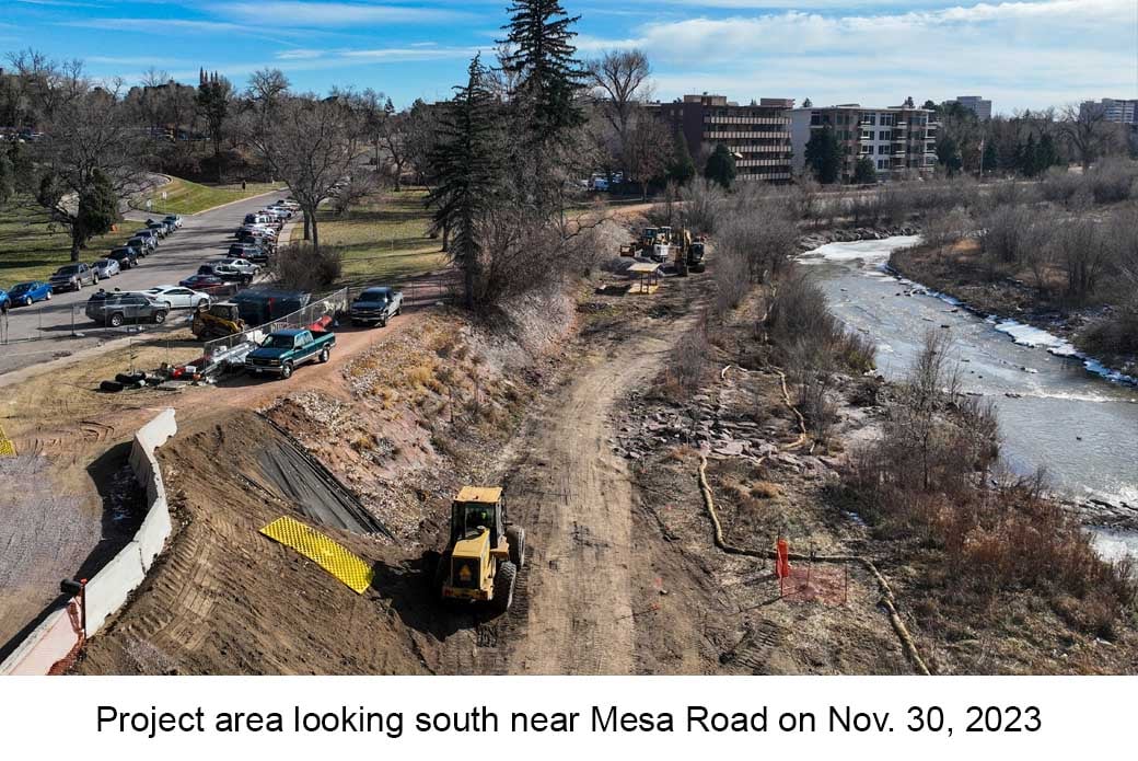 Aerial photo of Monument Creek near Colorado College taken on November 30, 2023. A yellow excavator is parked near the embankment next to the creek.