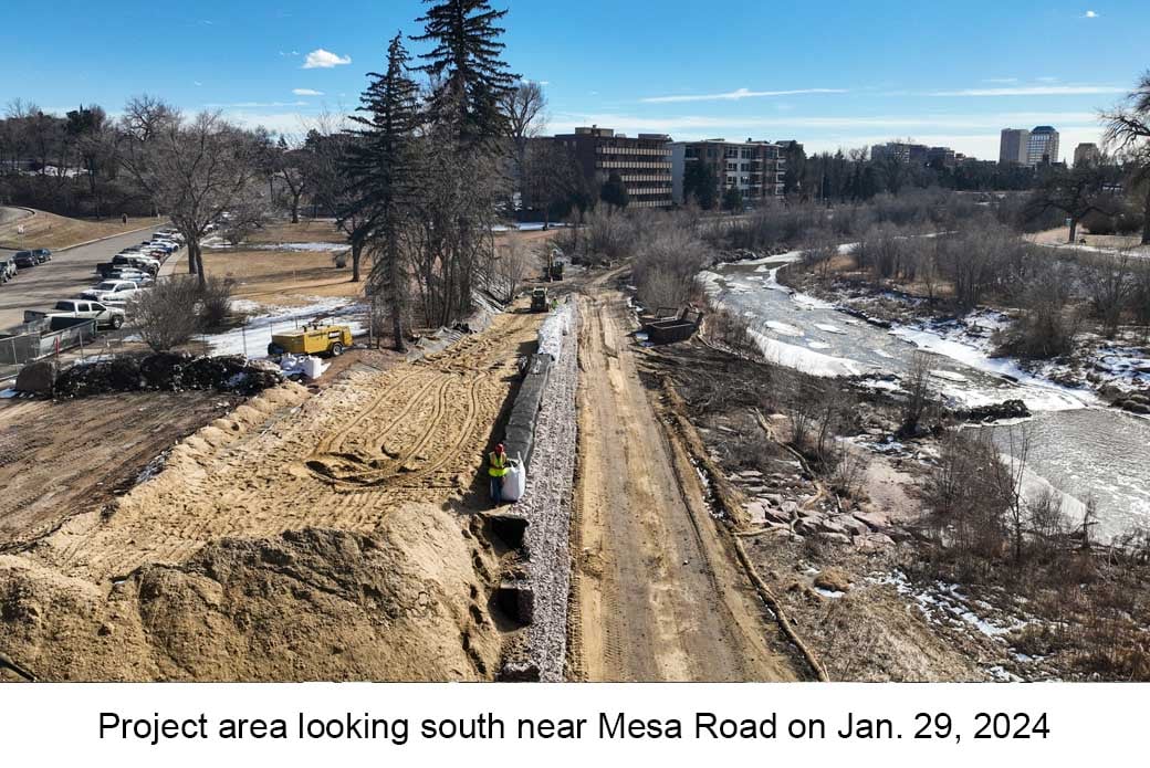 Aerial photo of Monument Creek taken on January 29, 2024. A dirt road runs through the center next to a newly constructed rock retaining wall.