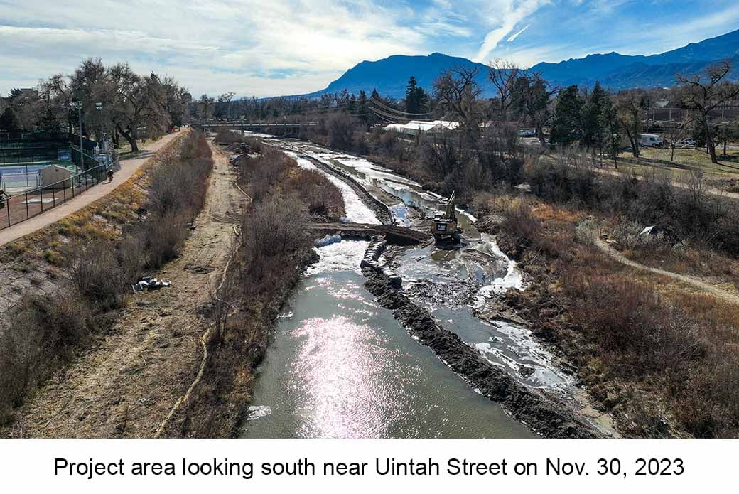 Photo of Monument Creek taken near the Uintah bridge on November 30, 2023. A backhoe is in the creek next to a small dirt road extending to the bank.