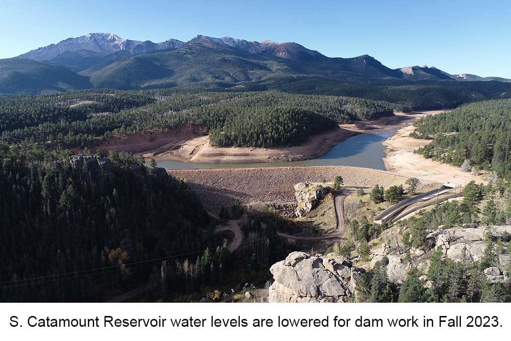 Aerial view of S. Catamount Reservoir. The water is low & muddy. Text reads: "S. Catamount water levels are lowered for dam work in Fall 2023"